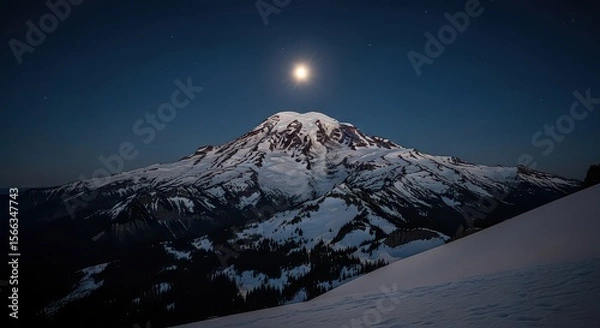 Fototapeta A snow-covered mountain rises against a dark blue sky illuminated by a bright moon and stars, showcasing a winter landscape for adventure and exploration.