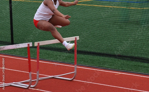 Obraz Athlete Jumps Over Hurdles During a Track Hurlde Rac3e
