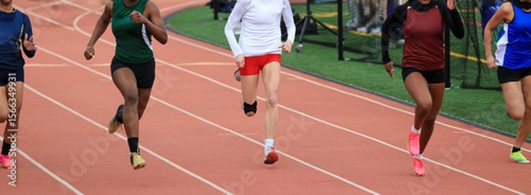 Obraz Five High School Girls Sprinting on a Track During a Competitive Race