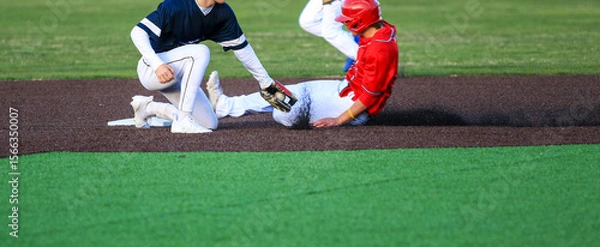 Obraz Runner Sliding into Second Base with the Short Stop Trying to Apply the Tag During a Baseball Game