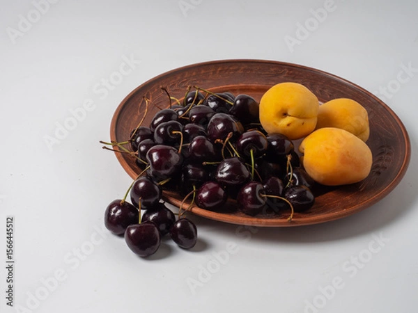 Fototapeta Sweet cherries with apricots isolated on white background cutout. Ripe berries closeup. Mix berries and fruits.