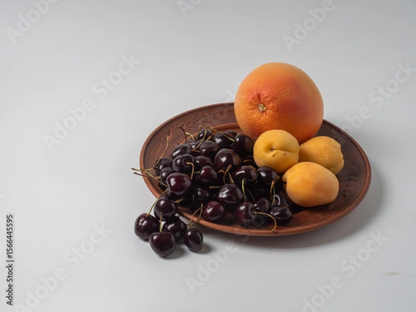 Fototapeta Sweet cherries with apricots isolated on white background cutout. Ripe berries closeup. Mix berries and fruits.