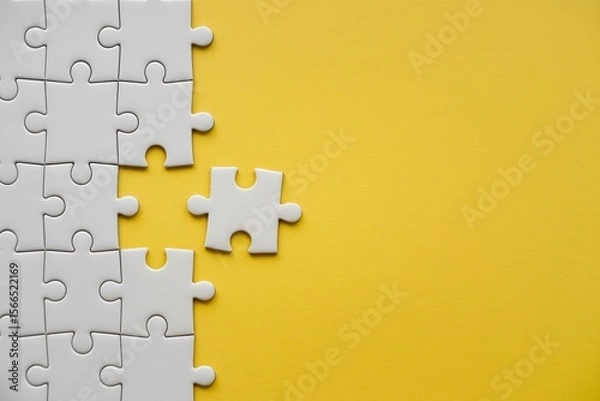 Fototapeta Missing puzzle piece on yellow background problem solving teamwork connection concept with copy space.