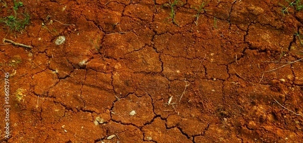 Fototapeta Long background, A close-up view of cracked red earth, symbolizing drought, dryness, and natural texture variations highlighting climate and environmental conditions.