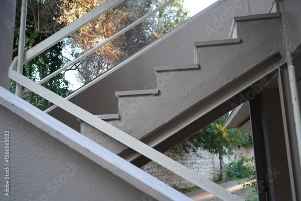 Obraz Stairs winding gracefully towards serene greenery in an afternoon light setting, revealing architectural elegance and natural beauty in harmony
