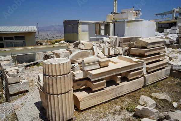 Obraz Remnants of ancient architecture atop a historical site under the bright midday sun, showcasing fragments of columns and stones awaiting restoration