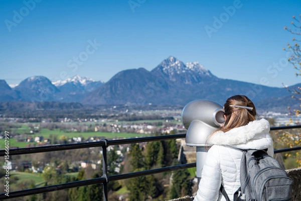 Obraz Mujer turista usando uno de los telescopios del castillo de Salzburgo para admirar las vistas de los Alpes Austríacos