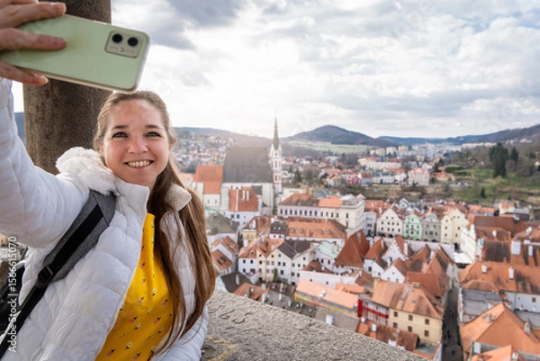 Obraz Mujer turista compartiendo las vistas de český krumlov con una selfie. Fotografía desde el mirador del castillo de český krumlov