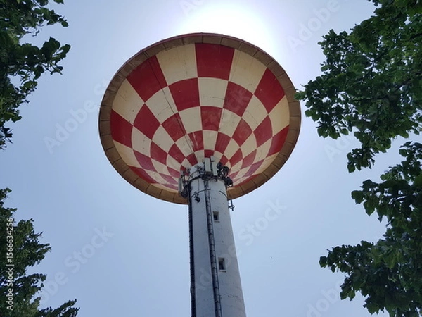 Fototapeta A view of a water tower in a park with blue sky.