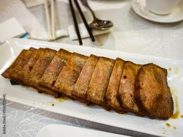 Fototapeta close up of Chinese spicy soy sauce marinated slices of beef ox tongue on a white plate