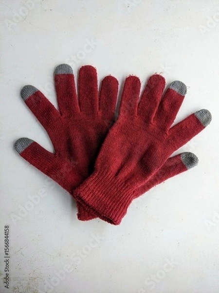 Fototapeta Pair of red touchscreen gloves isolated on a white background. Winter clothing and technology concept.