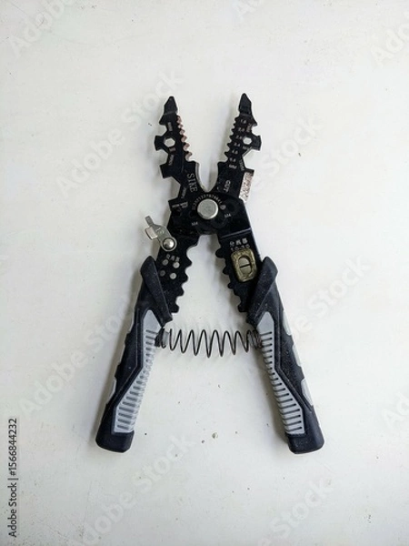 Fototapeta Open wire stripper and cutter tool showing its multifunctional jaws, isolated on a white background. Ready for electrical work or DIY project.