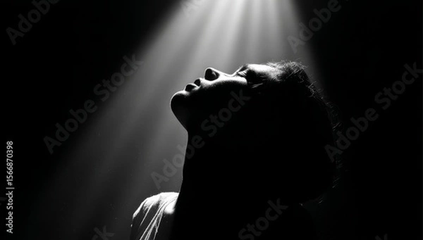 Obraz Silhouette of a Person Looking Upward in a Dramatic Spotlight