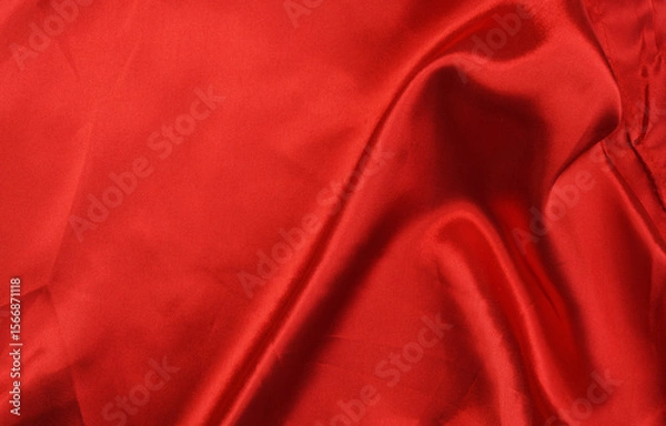 Fototapeta Rich red satin fabric draped elegantly across a surface.