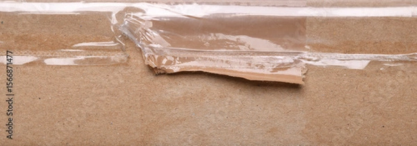 Fototapeta Surface of plain cardboard box with transparent plastic covering 