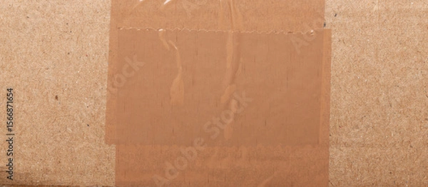 Fototapeta Surface of plain cardboard box with transparent plastic covering 