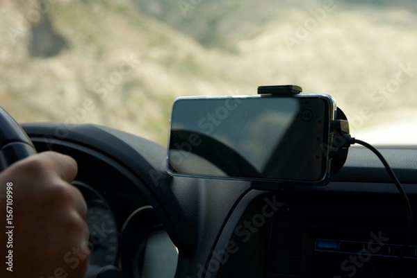 Fototapeta  Close-up of a car cabin fragment with a navigator on a smartphone.