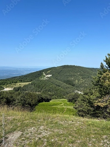Fototapeta Sunny Mountain Ridge and Valley View with Forest and Blue Sky