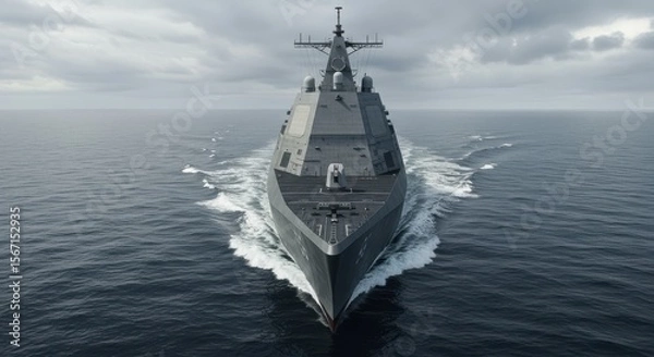 Fototapeta A low-angle photograph of a modern stealth destroyer, like a Zumwalt-class or Type 055, cutting through choppy ocean waters during a cloudy day. Focus on its angular, radar-evading 