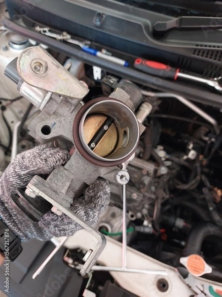 Fototapeta Car engine repair showing throttle body cleaning, sensor inspection, and spark plug maintenance during regular vehicle servicing