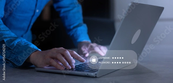 Fototapeta close up developer man hand type keyboard input username and password for register system software on laptop in dark operation office room for cyber security technology concept