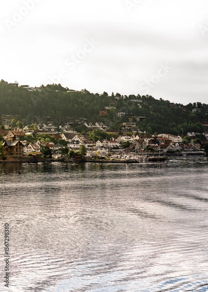 Fototapeta Warm morning sunlight on Drøbak, a charming town in Akershus County, welcomes tourists with its picturesque marina and sunny hillside views, perfect for day trips and sailing adventures