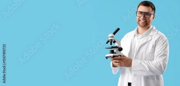 Fototapeta Male scientist with microscope on blue background with space for text