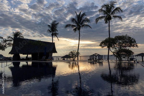 Obraz Sunrise over the swimming pool in a hotel with the reflection of the sky