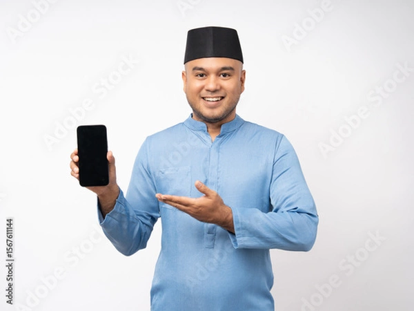 Obraz Muslim asian man standing using smartphone on isolated white background. Happy Portrait of cheerful smiling islamic asian man holding cell phone. People and lifestyle