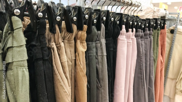 Obraz A variety of pants displayed on hangers in a retail store.