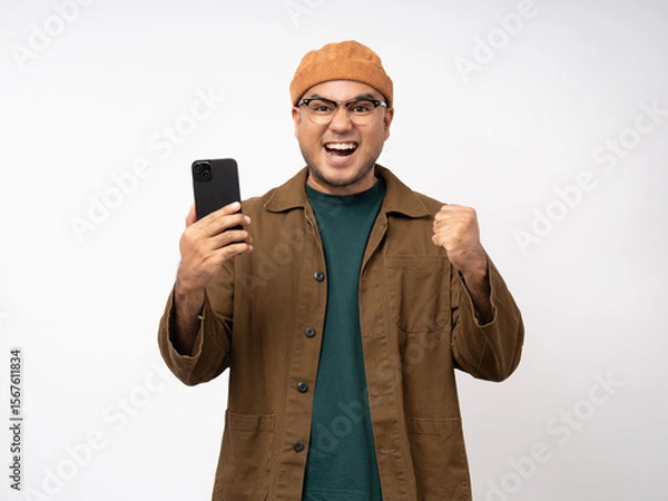 Obraz Young asian man using smartphone standing on isolated white background. He texting on cell phone. Dressing with jacket and jean.
