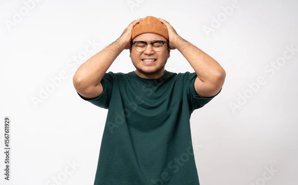 Obraz Handsome asian young man standing headache on isolated white background. Portrait of serious depressed asian man. People and lifestyle
