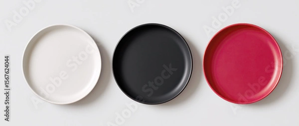 Fototapeta Three plates of different colors are shown on a white background