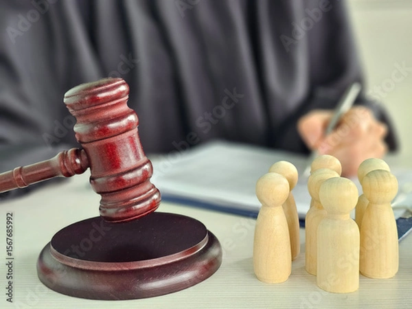 Fototapeta Legal proceedings involving wooden figures and a gavel on a desk highlighting courtroom