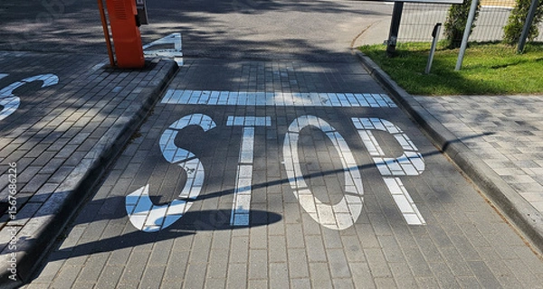Fototapeta Traffic stop marking on a paved street near a crossroad