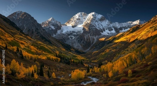Fototapeta Majestic mountain range and vibrant fall foliage, bathed in warm sunlight. River flows through the valley