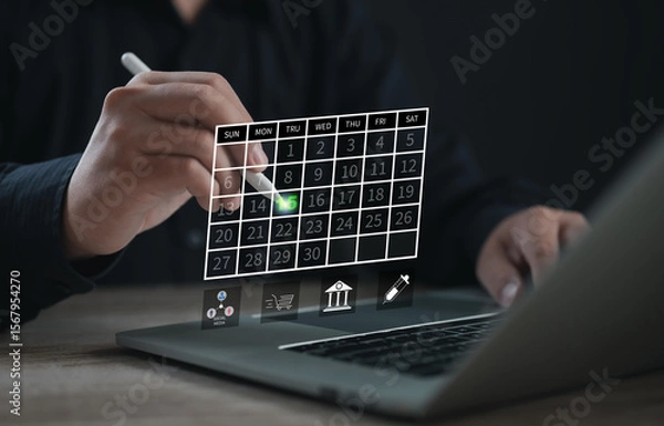 Fototapeta Business professional selecting a date on a digital calendar interface using a stylus on a laptop, representing smart scheduling, modern planning, and effective time management in business tasks.