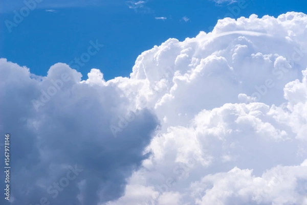 Fototapeta Piękne, bogato teksturowane chmury deszczowe na tle błękitnego nieba wiosennego. Duże chmury cumulonimbus dominują na żywym, błękitnym niebie. Wznoszące się formacje są gęste i falujące.