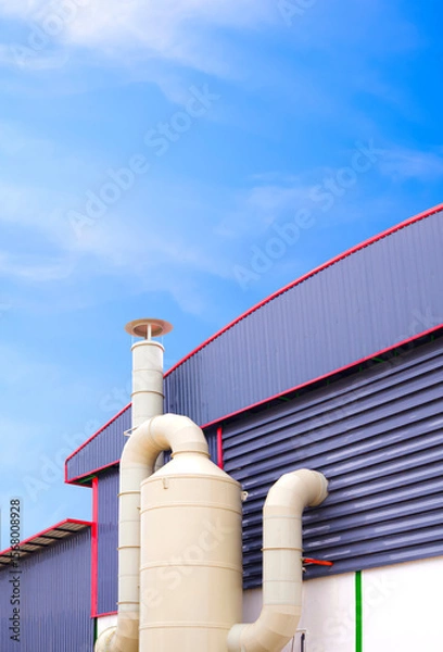 Fototapeta Wet scrubber exhaust air treatment system outside of production factory building against blue sky vertical background, low angle view with copy space