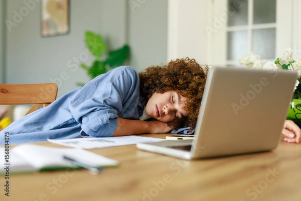Fototapeta Young Woman Resting on Desk in Home Office with Laptop and Documents on a Wooden Table
