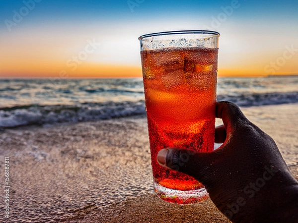 Fototapeta Italian soda drinks with strawberries and citrus photographed at the beach during sunset