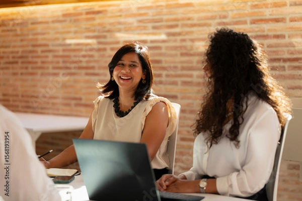 Obraz A young woman laughs during a meeting in the office in the office