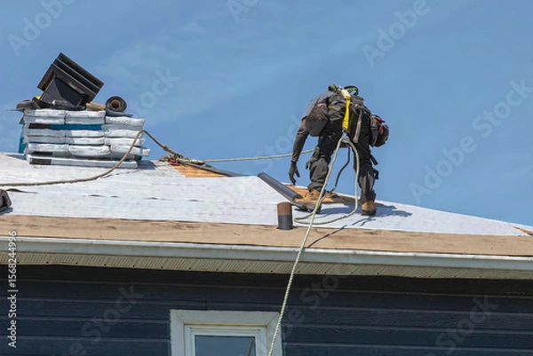 Obraz Construction Worker Installing Asphalt Shingles on House Roof
