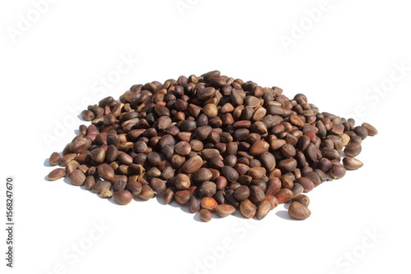 Fototapeta  There is a pile of unpeeled pine nuts on a white background.