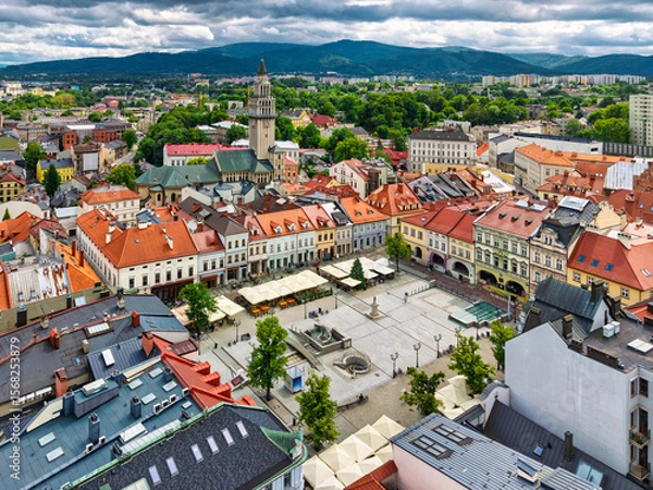 Fototapeta Aerial view of historic town square in Bielsko-Biała, Poland with colorful buildings and mountains in the background.