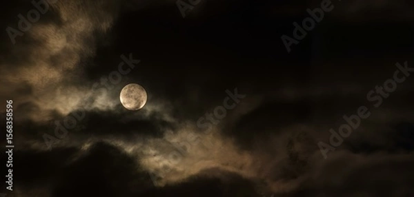Fototapeta Bright full moon shines through floating, dark, dramatic clouds.  For Halloween-themed design, mysticism or magic, weather forecast, background for text