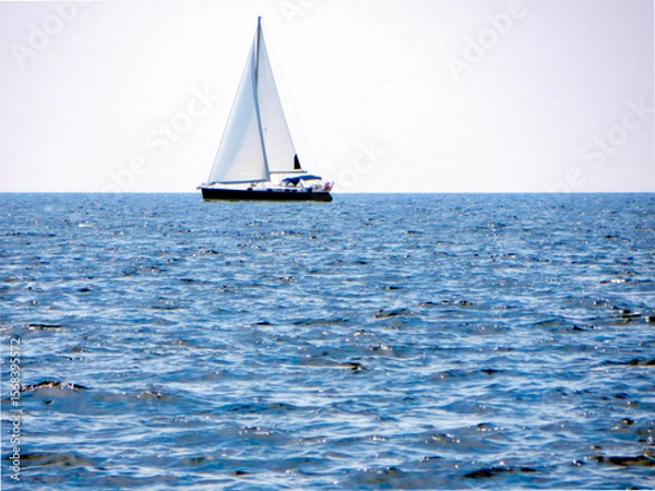 Fototapeta Sail Yacht Gliding Across Calm Waters Under a Bright Sky During a Serene Afternoon