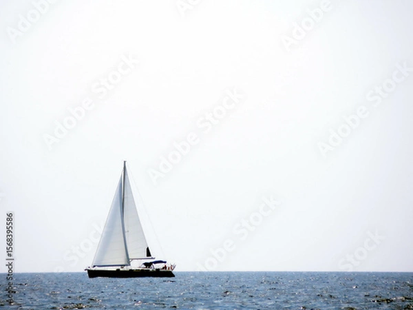 Obraz Sailing Yacht Gliding Across the Calm Sea Beneath a Clear Sky During Midday