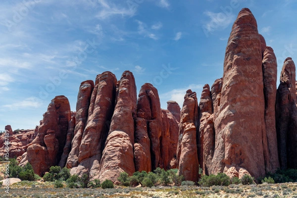 Fototapeta Landmark geological sandstone formation along the Broken Arch Trailhead with the Sand Dune Arch against a blue sky in Arches National Park, Moab, UT, USA