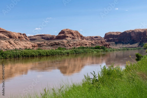 Fototapeta The Colorado River along the Potash Road near Moab, Utah, USA with geological sandstone formations reflected in the tranquil water